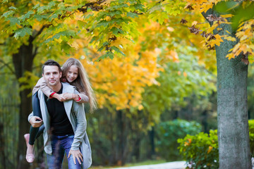 Fototapeta premium Father and his adorable little daughter outdoors on sunny autumn day