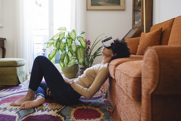 Woman sitting on the carpet with virtual reality headset