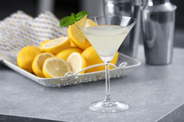 Glass with tasty lemon drop martini cocktail on table
