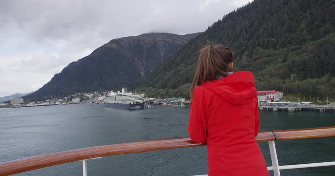 Alaska Cruise ship passenger in Juneau harbor looking at city view during cruise in Inside Passage.