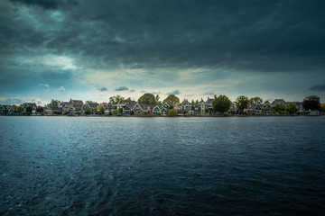 Traditional village with dutch windmills and river at sunset, Holland, Netherlands.