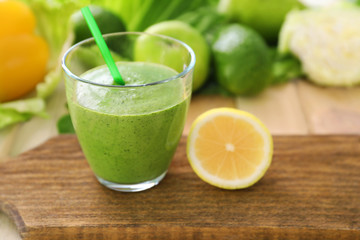 Healthy smoothie with kale in glass on wooden board