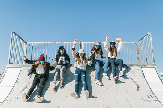 Five teen-age hipsters sliding down out of skate platform.
