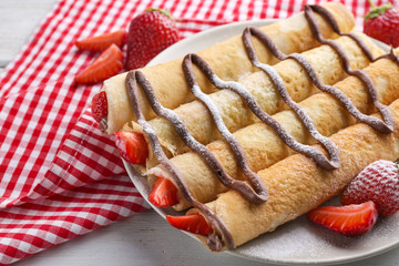 Delicious pancakes with chocolate and strawberry on plate