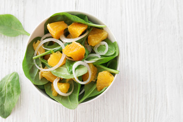 Plate of salad with spinach and orange  on table