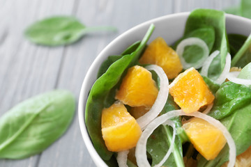 Salad with spinach and orange in bowl, closeup