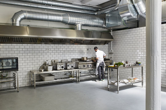 Male Chef Cooking In Professional Kitchen