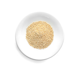 Plate with raw quinoa grains on white background