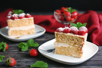 Slice of delicious cake decorated with strawberries on white plate