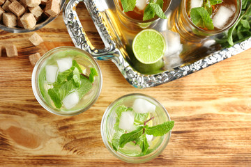 Composition with mint julep and metal tray on wooden table