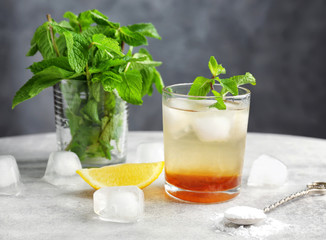 Composition with mint julep, lemon and ice on table
