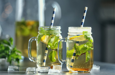Mason jars with mint julep on blurred background