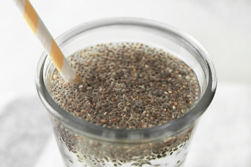 Chia seeds in glass of water on blurred background