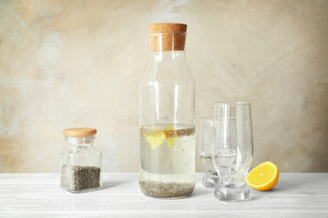 Composition with glassware, chia seeds, water and lemon on light background
