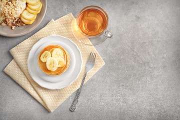 Plate with yummy banana pancakes on kitchen table