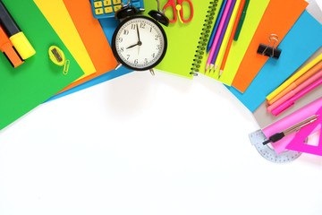 Colorful school supplies, book, and alarm clock on white. Top view, flat lay. Top view, copy space.