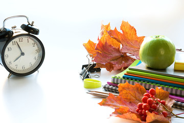 Colorful school supplies, book, and alarm clock on white. Top view, flat lay. Top view, copy space. Back to school.