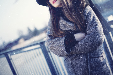 Girl in a freezing snow storm. Headless portrait. Red lips showing. Wearing hat and coat. - obrazy, fototapety, plakaty