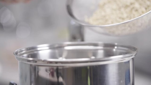 Chef spoons couscous out of colander, slow motion