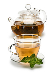 Fresh mint and green tea in a cup and a teapot from glass