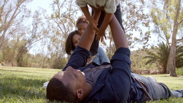Parents playing with their young kids in the park, low angle