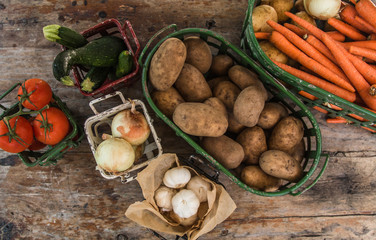 Vegetables in metal baskets on distressed vintage wood background 
