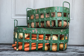 Vegetables in metal baskets on distressed vintage wood background 