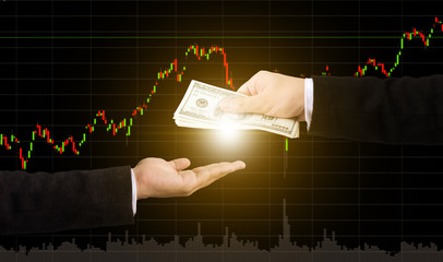 Hand holding money transfer with graph stock market blurred background, Finance and investment concept