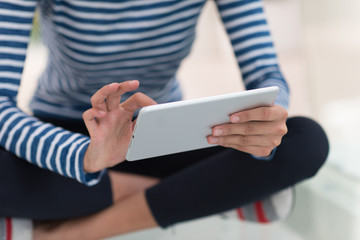 young women using tablet computer on the floor