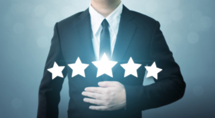 Young executive businessman in suit and five star symbol to increase rating of company, The...