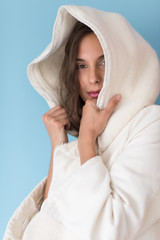 woman in a white coat with hood isolated on blue background