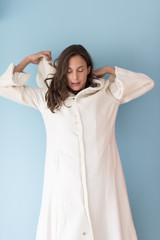 Fototapeta premium woman in a white coat with hood isolated on blue background