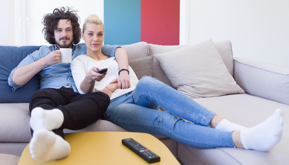 Fototapeta na wymiar Young couple on the sofa watching television