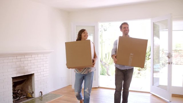 Couple Carrying Boxes Into New Home On Moving Day