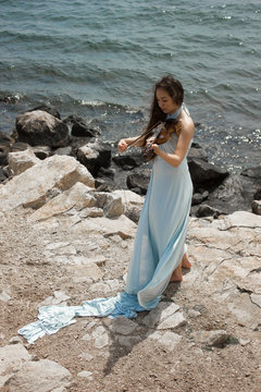 Girl playing violin at the beach in blue 3