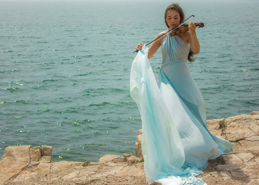 Girl playing violin at beach 1