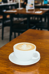 Hot latte coffee in white cup on table in restaurant and cafe