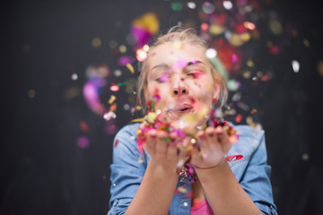 woman blowing confetti in the air