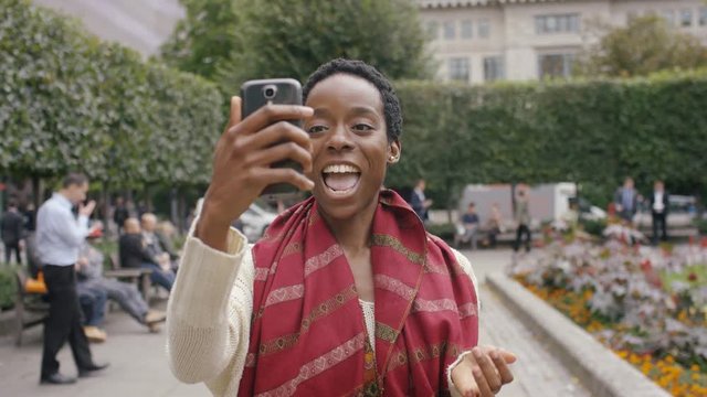 Attractive young black woman using her phone to record herself for social media