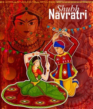 Couple performing Garba dance in Dandiya Raas for Dussehra or Navratri