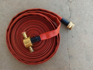 roll of old fire pipe on dirty concrete ground