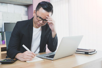 Fototapeta premium Asian businessman feeling headache and stress in office space background.Concept of Healthcare and Office syndrome.