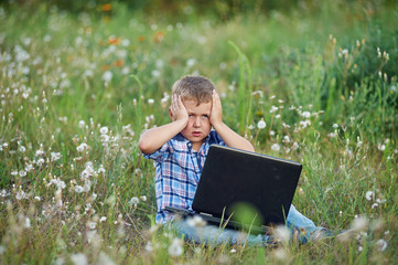 the boy sitting in Park with laptop