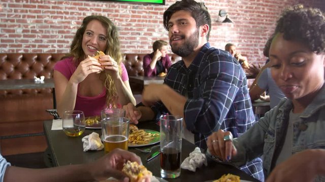 Group Of Friends Eating Out In Sports Bar Shot On R3D