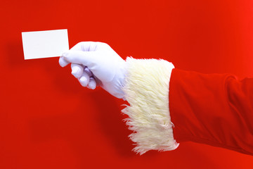 Santa Claus hand presenting your christmas text or product over red background with copy space