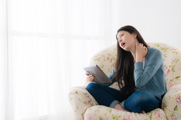 Obraz premium attractive girl sitting on sofa using mobile pad