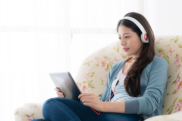 girl wearing headphone connecting digital tablet