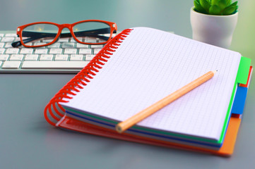 office desk with a phone notebook and computer
