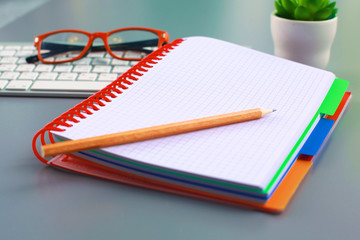 office desk with a phone notebook and computer