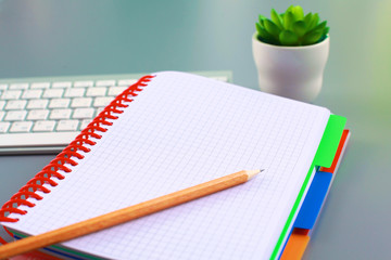 office desk with a phone notebook and computer